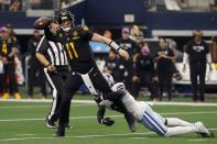 Washington Commanders quarterback Carson Wentz (11) throws a pass under pressure from Dallas Cowboys safety Donovan Wilson (6) in the second half of a NFL football game in Arlington, Texas, Sunday, Oct. 2, 2022. Wentz was penalized for intentional grounding on the play. (AP Photo/Ron Jenkins)