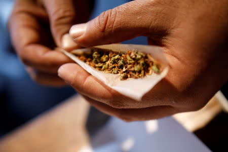 FILE PHOTO: A man prepares a cigarette mixed with marijuana during Cannatech 2017, an annual global cannabis industry event, in Tel Aviv, Israel March 20, 2017. REUTERS/Amir Cohen/File Photo