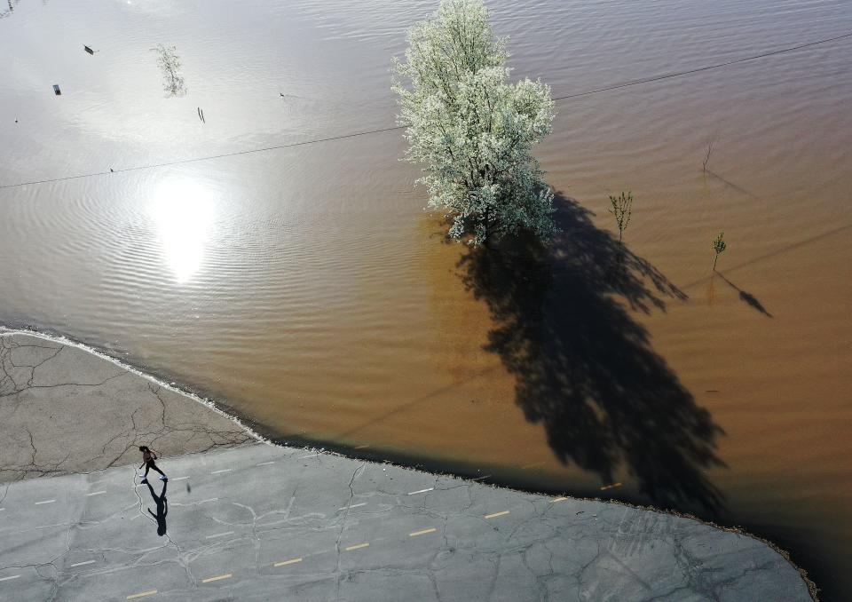 A walker goes around a flooded area in Sugarhouse Park in Salt Lake City on Tuesday, May 2, 2023. | Jeffrey D. Allred, Deseret News