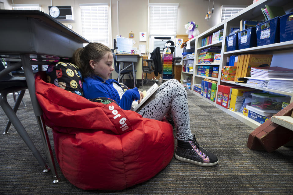 FILE - Third-grader Fallon Rawlinson reads a book at Good Springs Elementary School in Good Springs, Nev., on March 30, 2022. For decades, there has been a clash between two schools of thought on how to best teach children to read, with passionate backers on each side of the so-called reading wars. But the approach gaining momentum lately in American classrooms is the so-called science of reading. (Steve Marcus/Las Vegas Sun via AP, File)