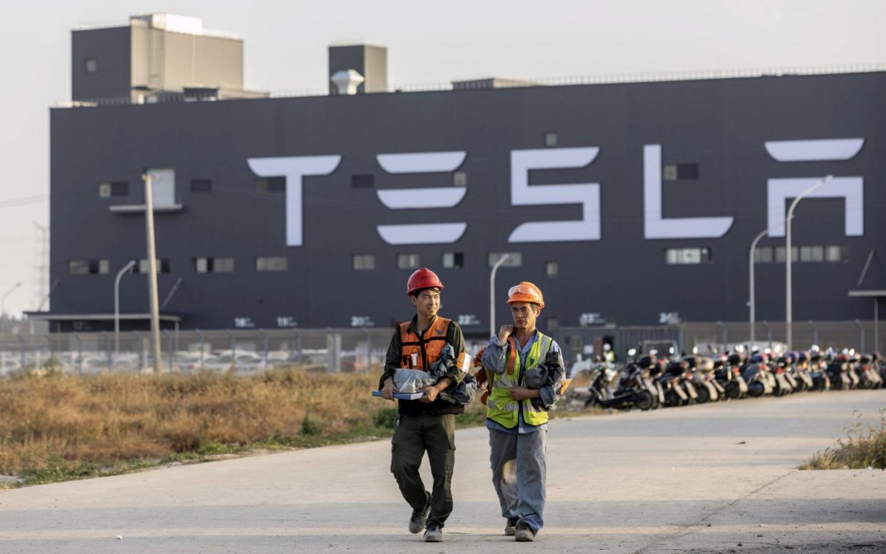 Workers walk outside the Tesla Inc. Gigafactory in Shanghai, China, on Friday, Nov. 1, 2019. - Bloomberg