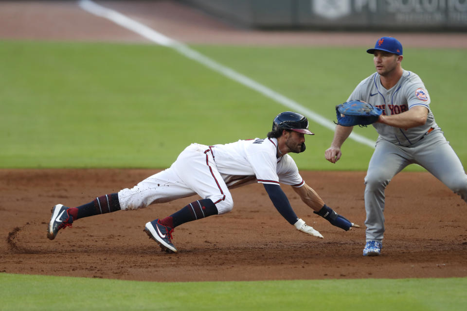 Atlanta Braves' Dansby Swanson, left, dives back to first base ahead of the throw to New York Mets first baseman Pete Alonso, right, in the second inning of a baseball game Saturday, Aug. 1, 2020, in Atlanta. (AP Photo/John Bazemore)