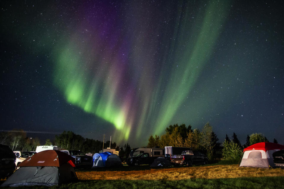 Evacuees from the wildfires in Yellowknife, territorial capital of the Northwest Territories, are greeted with the Aurora Borealis as they arrive at a free campsite provided by the community in High Level, Alberta, on Aug. 18, 2023. (Jason Franson /The Canadian Press via AP)
