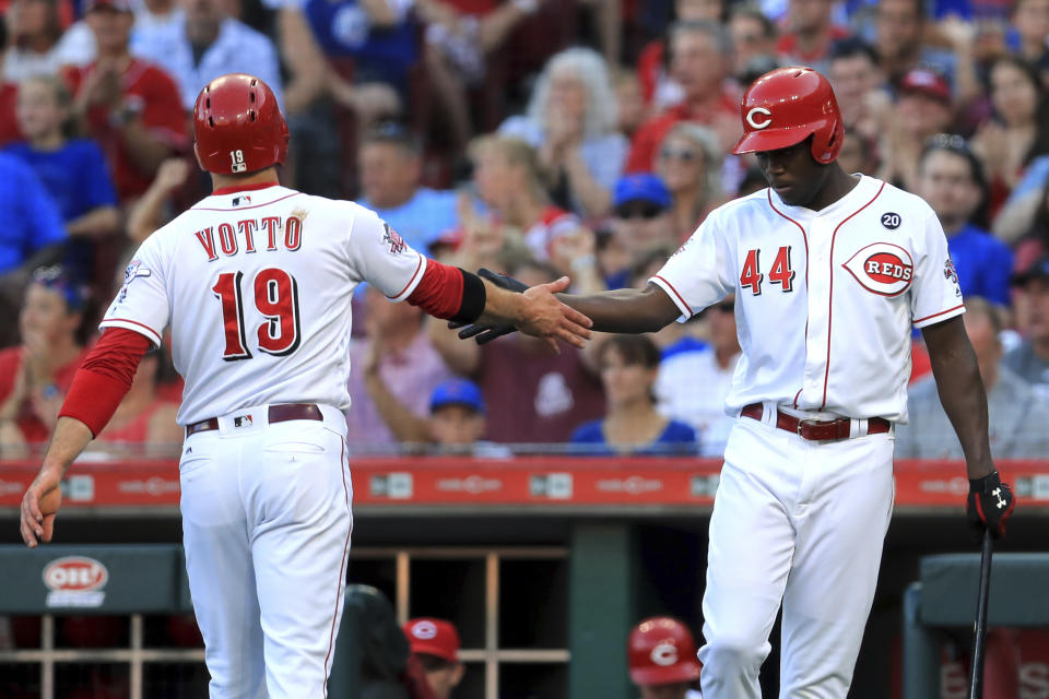 Cincinnati Reds' Joey Votto celebrates with teammate Aristides Aquino (44) after scoring a run on an RBI-double by Josh VanMeter in the first inning inning of a baseball game against the Chicago Cubs, Saturday, Aug. 10, 2019, in Cincinnati. (AP Photo/Aaron Doster)