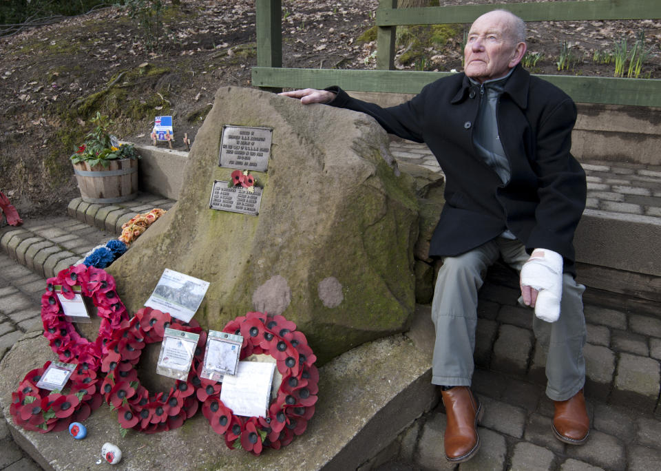 Tony Foulds sits next to a memorial honouring 10 U.S. airmen who died in a plane crash in Endcliffe Park, Sheffield, England, Wednesday, Feb. 13, 2019. Foulds was just a kid running around in the park on Feb. 22, 1944 when a U.S. Air Force crew decided to crash and die rather than take the chance of hitting them. He's dreamed of honoring them for decades. Now he's 82 and about to get his wish. (AP Photo/Rui Vieira)