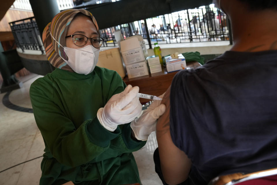 A health worker gives a shot of the Sinovac COVID-19 vaccine to a man during a mass vaccination in Jakarta, Indonesia, Monday, June 21, 2021. Indonesia's president ordered authorities to speed up the country's vaccination campaign as the World Health Organization warned of the need to increase social restrictions in the country amid a fresh surge of coronavirus infections caused by worrisome variants. (AP Photo/Dita Alangkara)