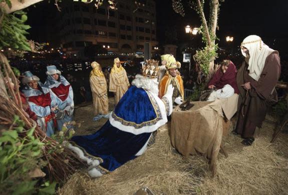 Men dressed as the "Three Wise Men" present gifts to a baby playing the part of Jesus during the annual Epiphany parade through central Burgos, Spain, January 5, 2012. REUTERS/Felix Ordonez