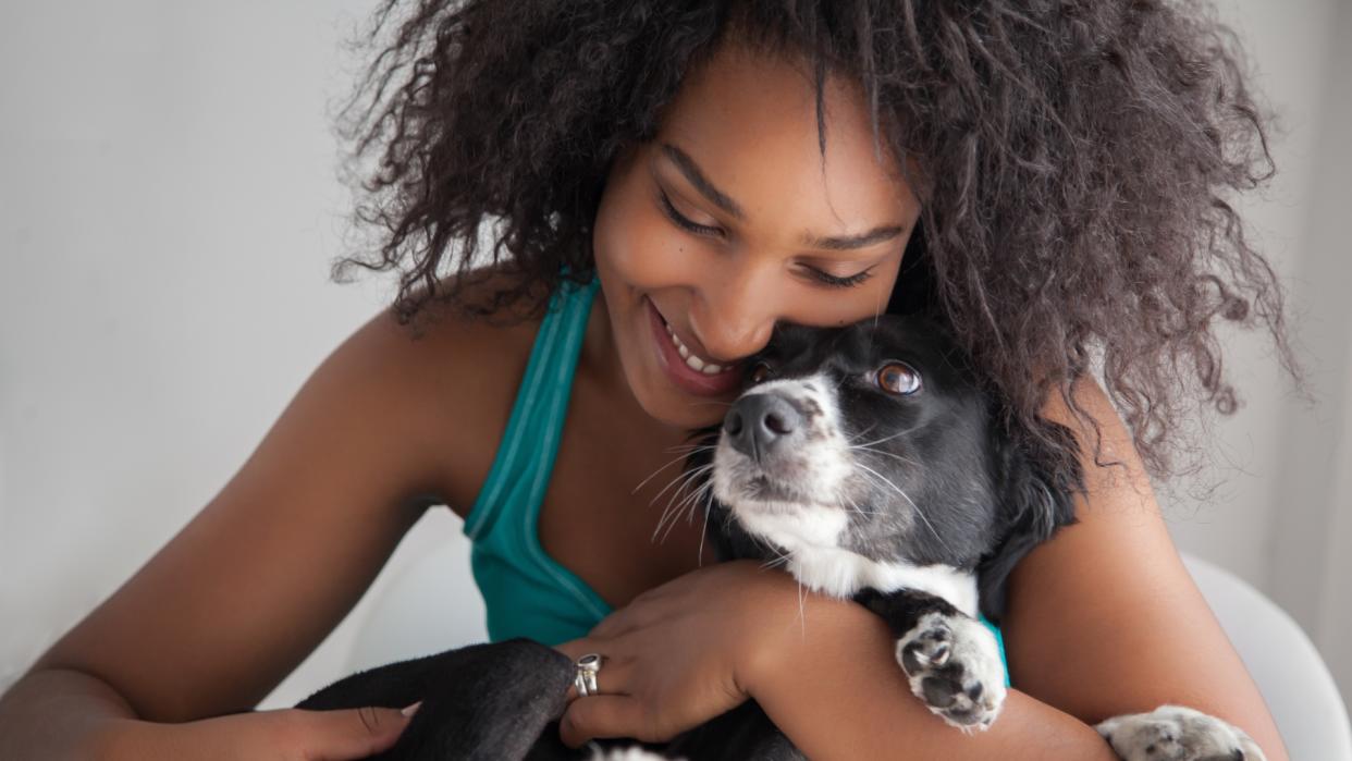  Young woman hugging her dog. 