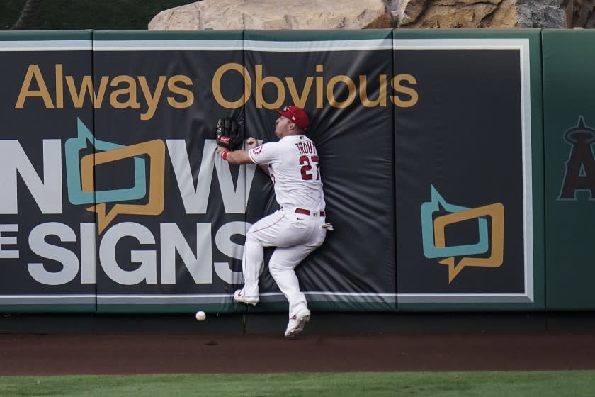 Los Angeles Angels' Mike Trout collides with the wall while trying to catch a triple hit by Houston Astros' George Springer during the fifth inning of the first baseball game of a doubleheader, Saturday, Sept. 5, 2020, in Anaheim, Calif. (AP Photo/Jae C. Hong)