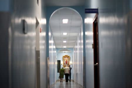 People walk in a corridor of the hospital Auxilio Mutuo, that houses liver and kidney transplant centers, in San Juan, October 20, 2015. REUTERS/Alvin Baez