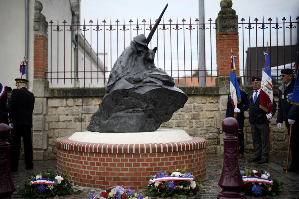 A sculpture by French-Columbian artist Milthon shows a WWI French soldier and his dog huddled together, during a ceremony in Suippes, eastern France, Thursday, Oct. 20, 2022. France inaugurated on Thursday its first memorial paying tribute to all "civilian and military hero dogs". The monument is located on a key World War I site, echoing the important role played by dogs in U.S. and European armies at the time. (AP Photo/Christophe Ena)