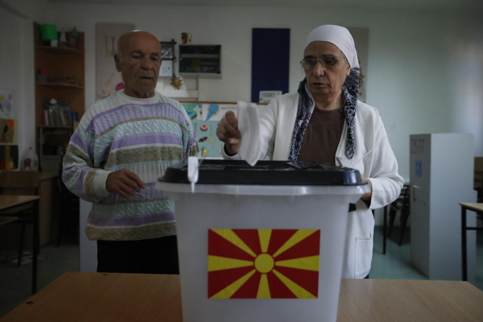 An ethnic Albanian woman casts her ballot in at a polling station during a referendum in Skopje, Macedonia, Sunday, Sept. 30, 2018. Macedonians were deciding Sunday on their country's future, voting in a crucial referendum on whether to accept a landmark deal ending a decades-old dispute with neighbouring Greece by changing their country's name to North Macedonia, to qualify for NATO membership and also pave its way toward the European Union. (AP Photo/Thanassis Stavrakis)