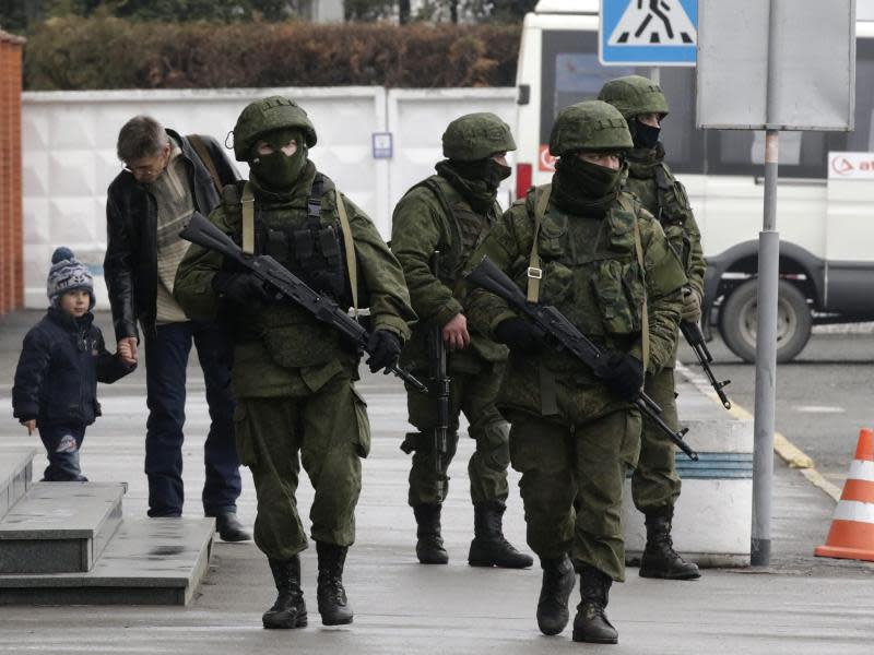 Informiert und schwer bewaffnet patrouillieren Männer am Flughafen in Simferopol. Foto: Maxim Shipenkov