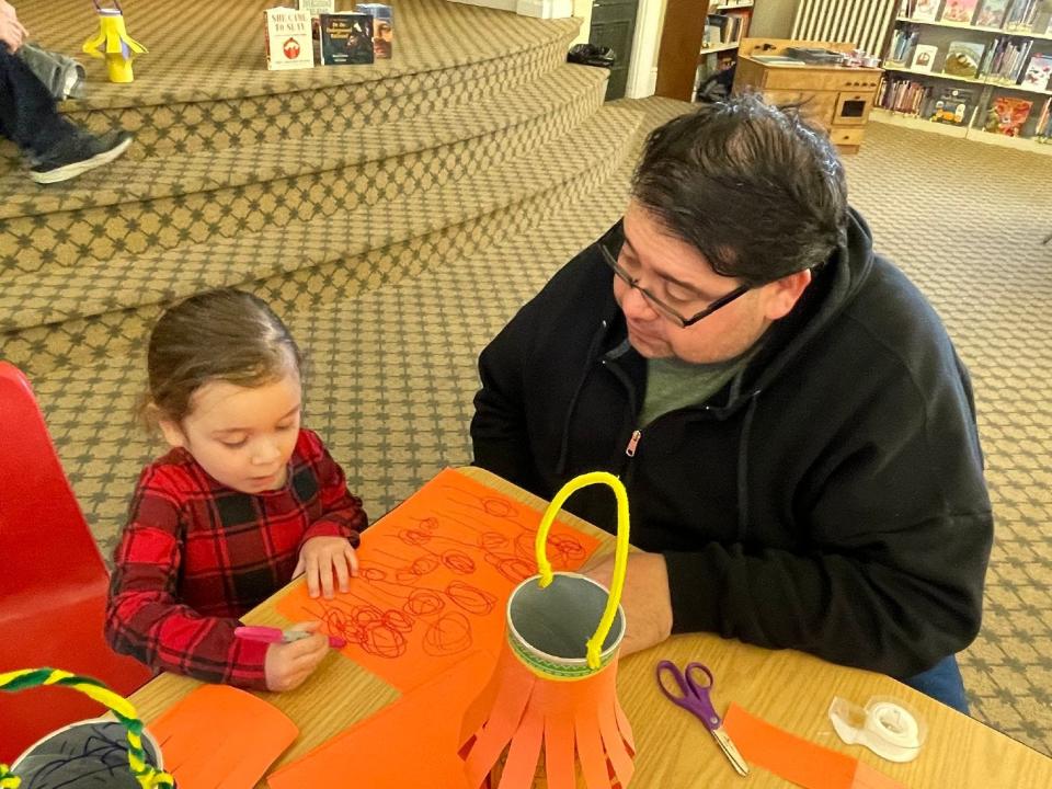 Cristoval Mendoza of Monroe watches as his daughter, Ella, 3, makes a liberty lantern Saturday at the Dorsch Memorial Branch Library.