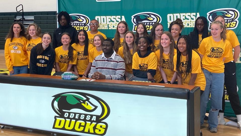 Odessa senior Jeremiah Green (center), who plans to play football at Concord University, poses for a photo with some of his biggest fans - the girls soccer team - during the Ducks’ first athletic signing ceremony on Thursday.