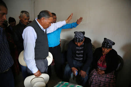 A pastor prays along Gilberto Gomez and Lidia Gonzalez in memory of their daughter Claudia Gomez, a 19-year old Guatemalan immigrant who was shot by an U.S. Border Patrol officer, at their home in San Juan Ostuncalco, Guatemala May 27, 2018. REUTERS/Luis Echeverria