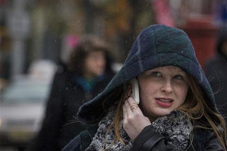 A woman talks on her mobile phone as the rain begins to fall in New York November 26, 2013. REUTERS/Brendan McDermid (UNITED STATES - Tags: ENVIRONMENT SOCIETY)