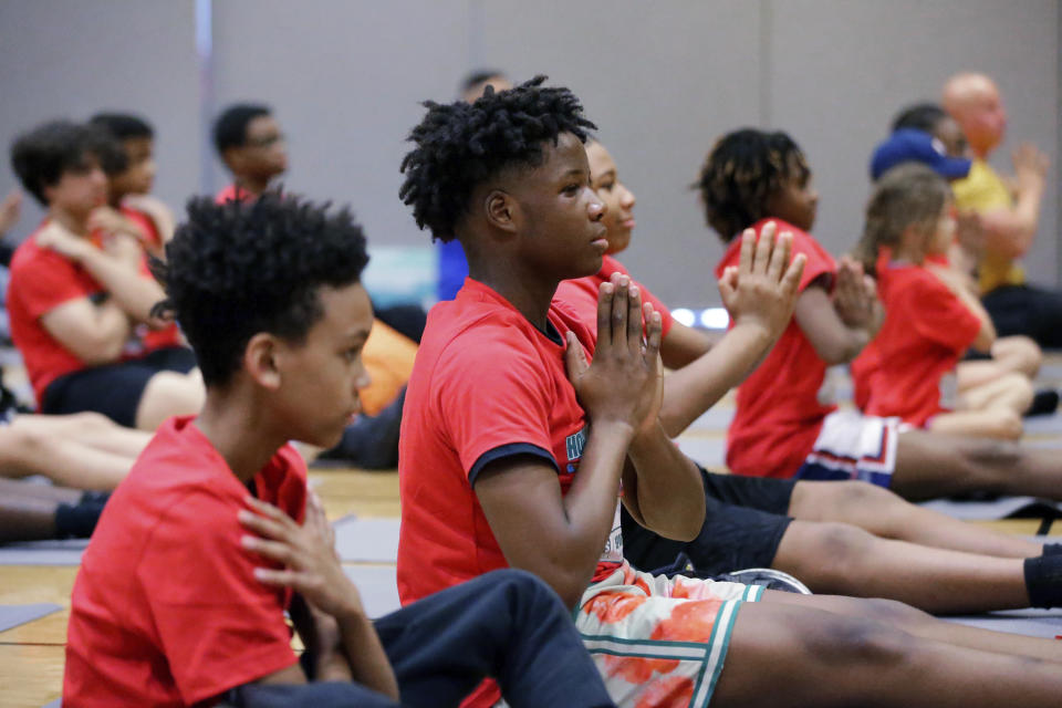 Kids take part in a yoga class during Sports Matter Day at the University of Houston, Saturday, Dec. 3, 2022, in Houston. (AP Photo/Michael Wyke)