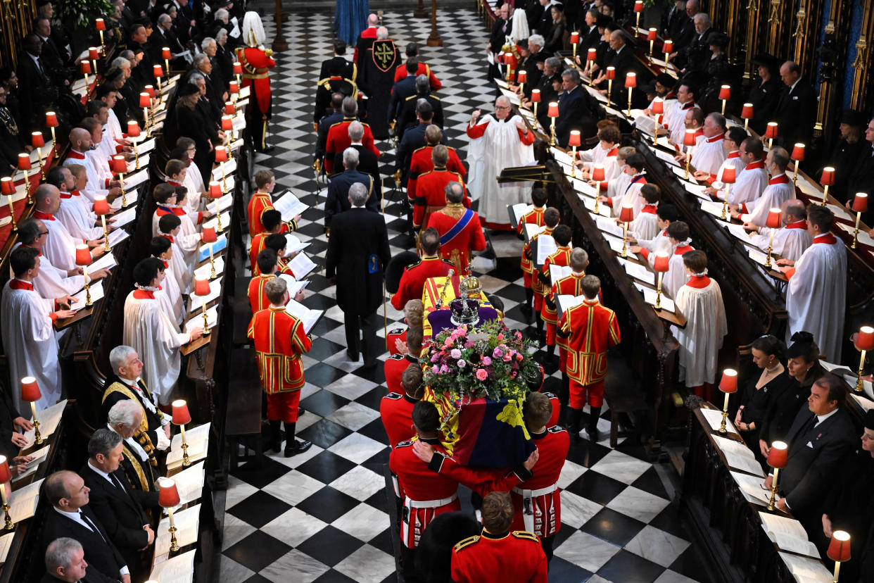 The coffin of Queen Elizabeth II, draped in a Royal Standard and adorned with the Imperial State Crown and the Sovereign's orb and sceptre arrives during the State Funeral Service for Queen Elizabeth II at Westminster Abbey