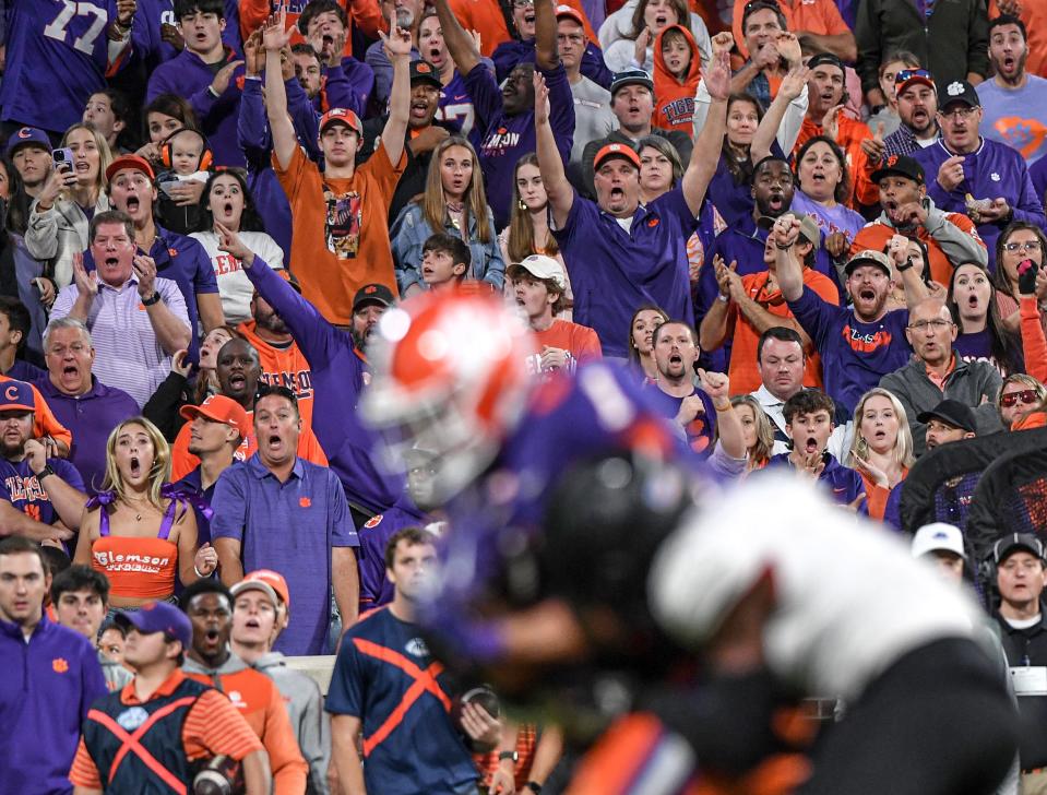 Clemson fans react with disbelief as Clemson running back Will Shipley splits two Louisville defenders after leaping over another en route to a 25-yard touchdown in the third quarter at Memorial Stadium on Saturday, Nov. 12, 2022.