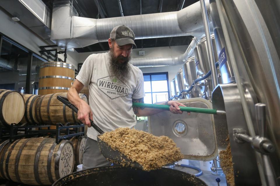 Wire Road Brewing Company Cellarman Quigg Ryan shovels spent grain from a tank at the brewery on Tuesday, May 2, 2023.