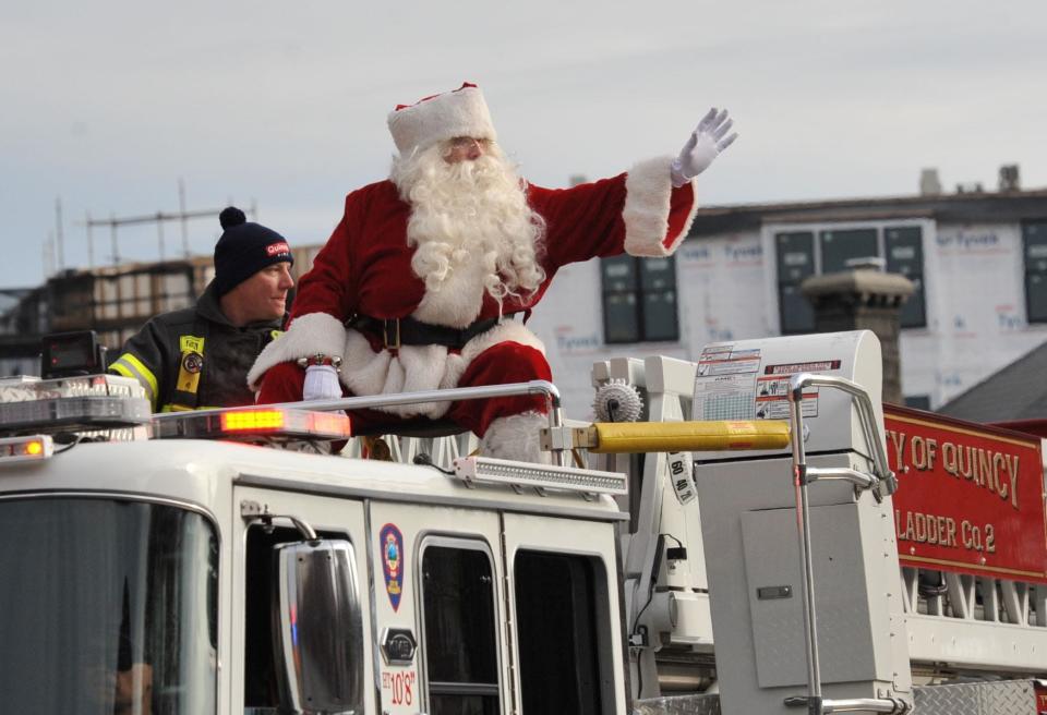 Santa Claus waves to the crowds from atop the Quincy Fire Department's Ladder 2 during the 68th Quincy Christmas Parade on Sunday, Nov. 28, 2021.