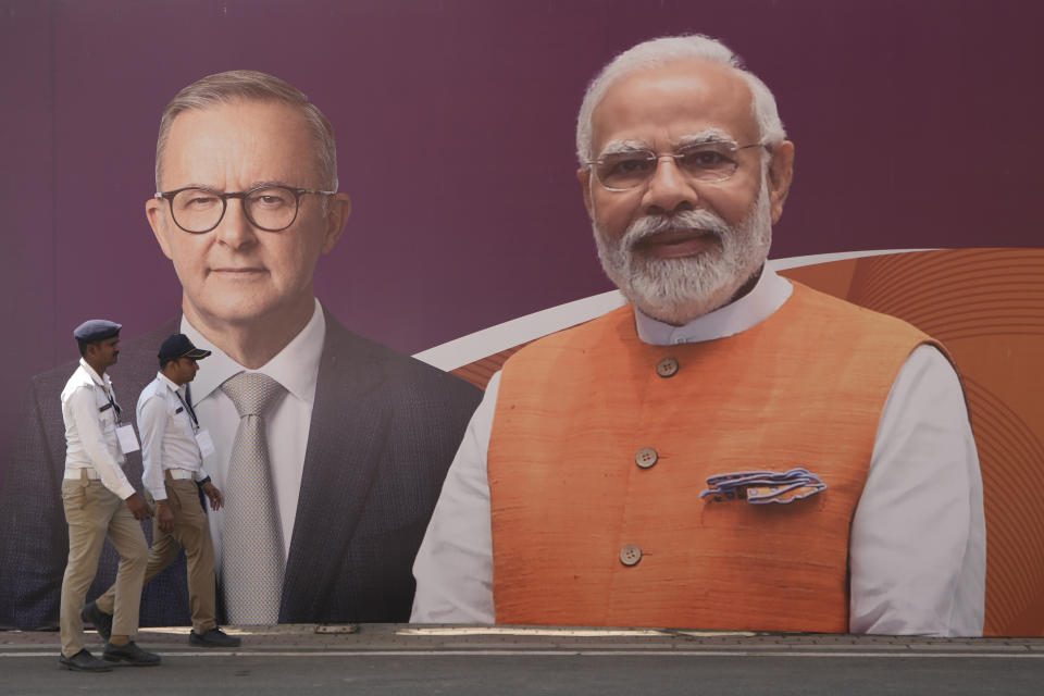 Policemen walk past a hoarding featuring Australian Prime Minister Anthony Albanese and Indian Prime Minister Narendra Modi ahead of the fourth test cricket match between India and Australia at Narendra Modi Cricket Stadium in Ahmedabad, India, Wednesday, March 8, 2023. (AP Photo/Ajit Solanki)