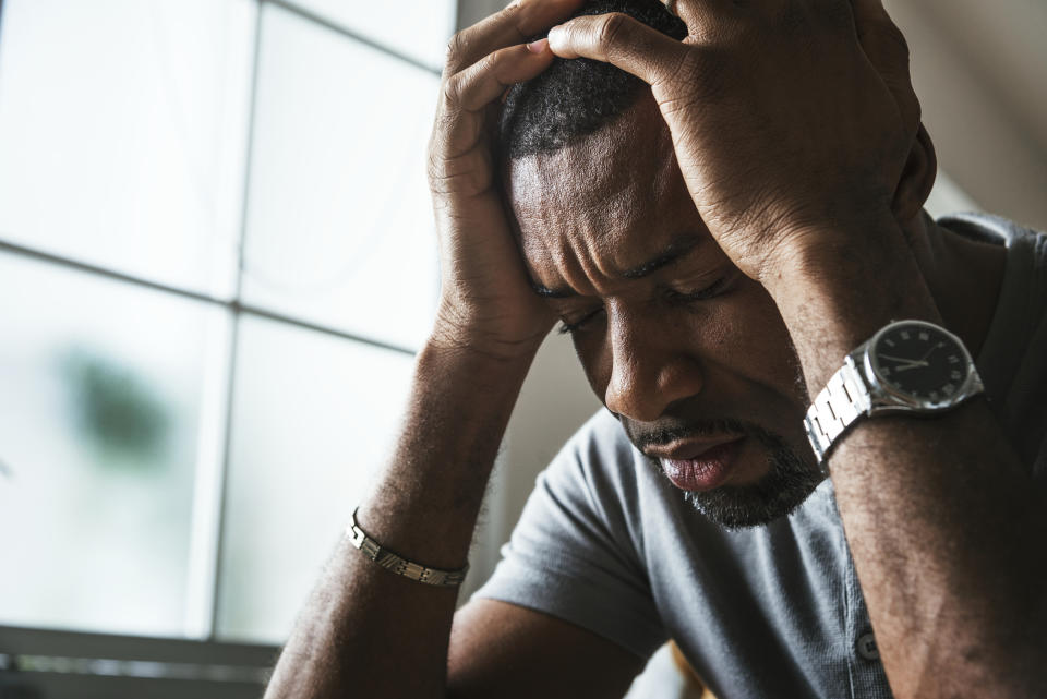 Man with hands on head showing distress or headache