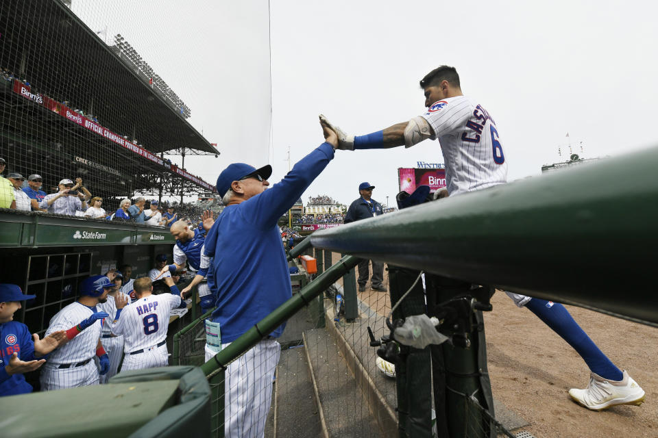 Chicago Cubs' Nicholas Castellanos right, celebrates with manager Joe Maddon left, at the dugout after hitting a two-run home run during the first inning of a baseball game against the Milwaukee Brewers Friday, Aug 30, 2019, in Chicago. (AP Photo/Paul Beaty)