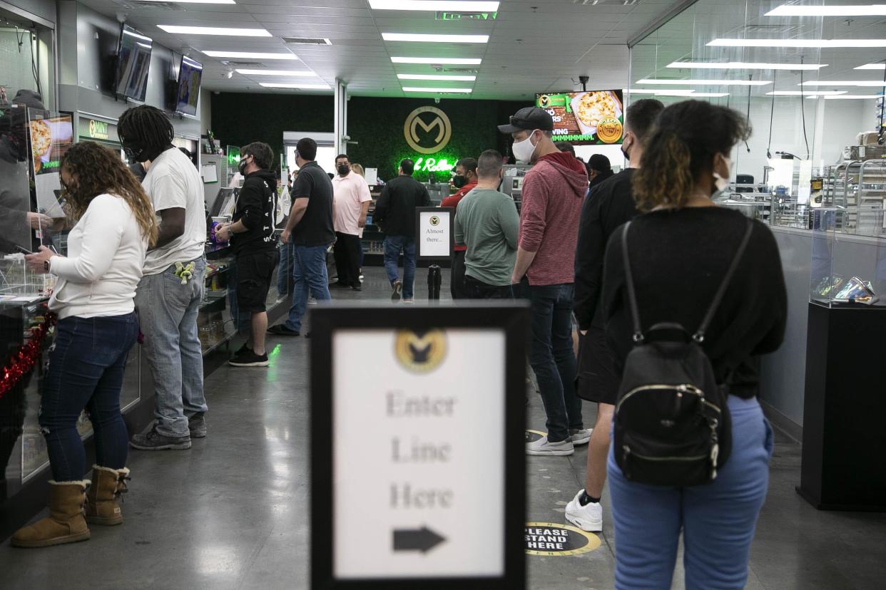 Dozens of customers line up outside of Mint Dispensary in Mesa, Ariz., on Jan. 22, 2021, an hour after Arizona health regulators approved the sale of recreational marijuana.