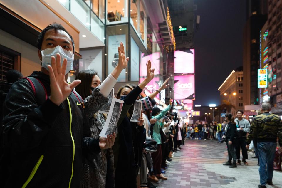 People gesture to show "five demands" as they form a human chain on New Year's eve in Hong Kong, Tuesday, Dec. 31, 2019. Months of pro-democracy protests have brought “sadness, anxiety, disappointment and even rage,” the city’s leader Carrie Lam said in a News Year’s address Tuesday. Protests that began in June over a proposed extradition law have spread to include demands for more democracy and other grievances. (AP Photo/Vincent Yu)
