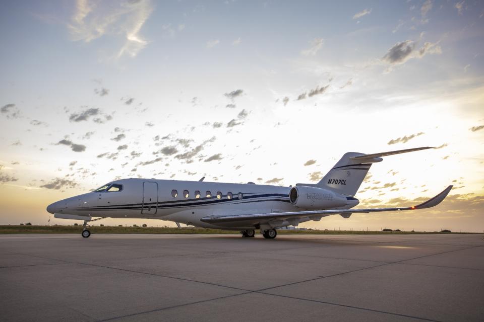 A Citation Longitude business jet parked in front of a sunset.