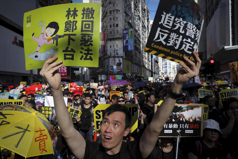 In this July 1, 2019, file photo, a protester holds placards during a rally on the 22nd anniversary of the former British colony's return to China. A national security law enacted in 2020 and COVID-19 restrictions have stifled major protests in Hong Kong including an annual march on July 1. Placards read: "Carrie Lam step down, revoke evil law, investigate police." (AP Photo/Kin Cheung, File)