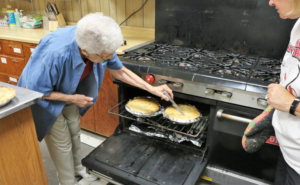 Shirley Perret, Quimby's matriarch and the Community Center's keyholder, tests the final pies to make sure they are done.