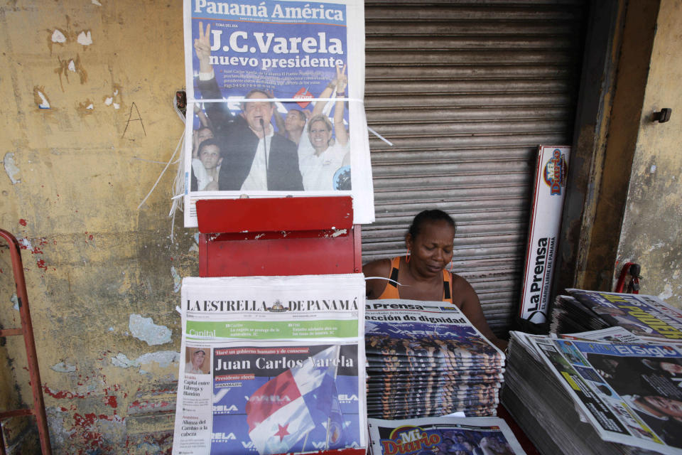 A woman sells newspapers carrying front pages announcing the winner of Panama's presidential election in Panama City, Monday, May 5, 2014. Vice President Juan Carlos Varela won Sunday's presidential election and will take office July 1. Varela studied engineering at the Georgia Institute of Technology and is the scion of one of Panama's richest families. (AP Photo/Arnulfo Franco)