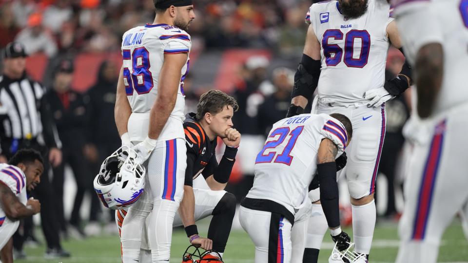 CINCINNATI, OHIO - JANUARY 02:  Quarterback Joe Burrow #9 of the Cincinnati Bengals and Jordan Poyer #21 of the Buffalo Bills take a knee after Damar Hamlin #3 of the Bills collapsed following making a tackle during the first quarter at Paycor Stadium on January 02, 2023 in Cincinnati, Ohio. (Photo by Dylan Buell/Getty Images)