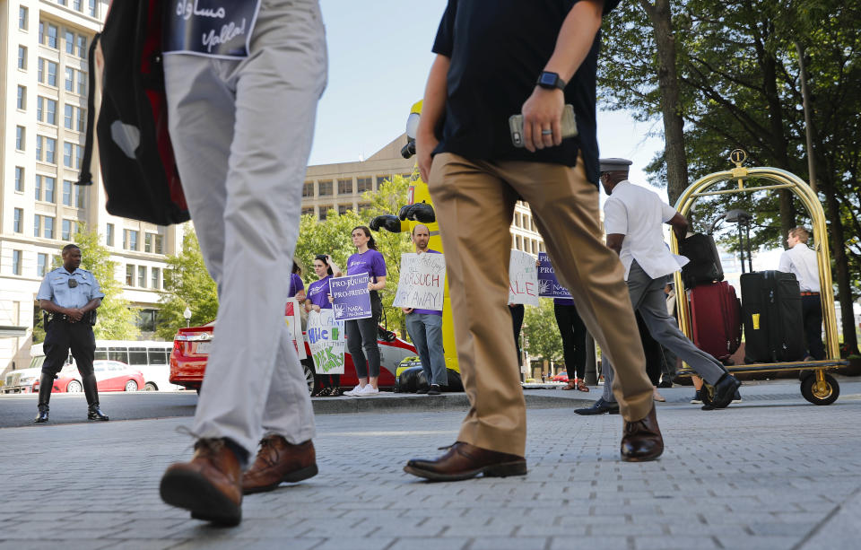 Hotel guest walk past demonstrators gathered in front of the Trump Hotel in Washington, Thursday, Sept. 28, 2017. Supreme Court Justice Neil Gorsuch is schedule to speak at a luncheon hosted by a conservative group at the Trump Hotel. (AP Photo/Pablo Martinez Monsivais)