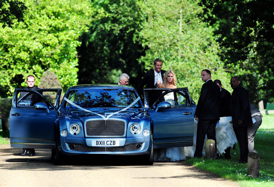 Footballer Peter Crouch and model Abbey Clancy, stand behind a door of a wedding car in the grounds of Stapleford Park in Leicester following their wedding.