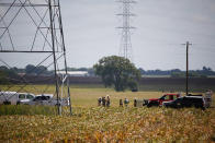 <p>Investigators surround the scene in a field near Lockhart, Texas where a hot air balloon carrying at least 16 people collided with power lines July 30, 2016. (Ralph Barrera/Austin American-Statesman via AP)</p>