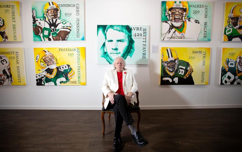 Dg Clearing, owner of Dg Clearing, a fine art gallery, poses for a portrait in front of works of art by James Hartel inside the gallery at 1270 Main St. in Green Bay. The paintings are part of the 421 series of paintings depicting milestones in former Green Bay Packer quarterback Brett Favre&#39;s 421 career touchdown passes.