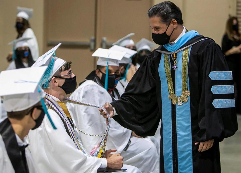 Miami-Dade County Schools Superintendent Alberto Carvalho (right) asks graduate Justin Perez (sitting, second from left) if he needs any more honors during the graduation ceremony for students of Miami Arts Studio 6-12 @ Zelda Glazer at the Miami-Dade Fair and Expo. Miami-Dade Public Schools began its high school graduations on Tuesday, June 1.