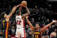 Miami Heat forward Jimmy Butler (22) shoots against Atlanta Hawks forward De'Andre Hunter (12) during the first half of an NBA basketball game, Tuesday, April 9, 2024, in Atlanta. (AP Photo/Mike Stewart)