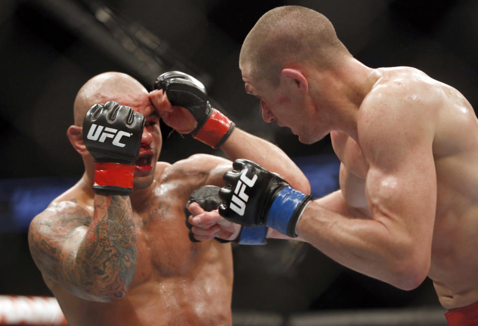 FILE - Thiago Alves, left, and Seth Baczynski fight in a mixed martial arts event on Saturday, April 19, 2014, at UFC Fight Night in Orlando Fla. UFC is set to unveil fighter gloves overhauled to minimize cuts and abrasions, but in large part designed to stunt eye pokes that often render fighters unable to continue, the first major change of the protective equipment in more than a decade.The global MMA leader made the impact-absorbing gloves mandatory, starting with Saturday’s, June 1, 2024, UFC 302 card in New Jersey. (AP Photo/Reinhold Matay, File)