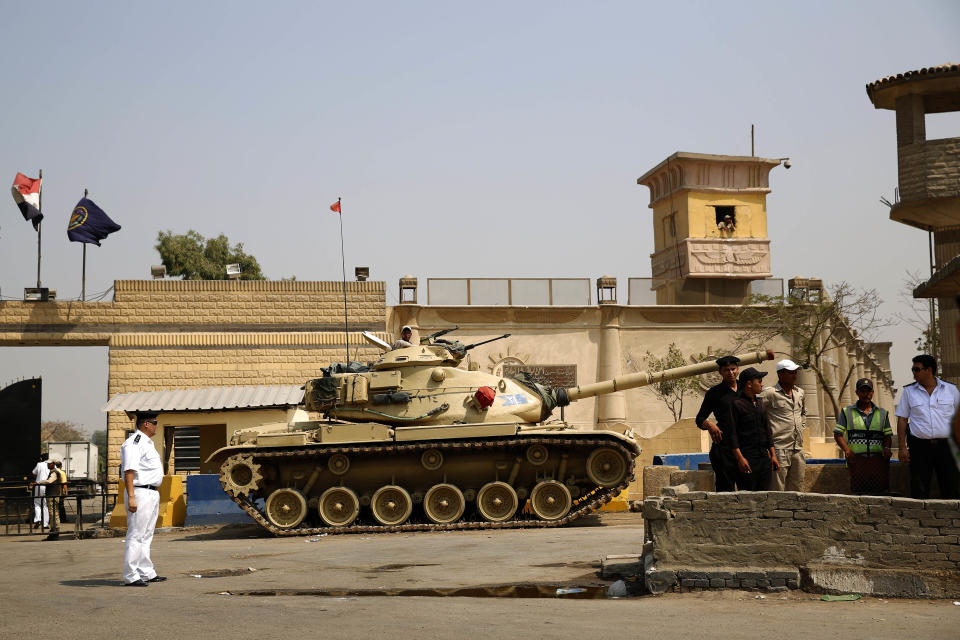 FILE - In this Aug. 2, 2015 file photo, Egyptian security forces stand guard outside one of the entrances of Tora prison, in Cairo, Egypt. Since the coronavirus first hit Egypt in February 2020, At least 10 doctors and six journalists have been arrested according to rights groups. Other health workers say they have been warned by administrators to keep quiet or face punishment. One foreign correspondent has fled the country, fearing arrest, and another two have been summoned for reprimand over their reporting of “disinformation" and other “violations.” (AP Photo/Hassan Ammar, File)