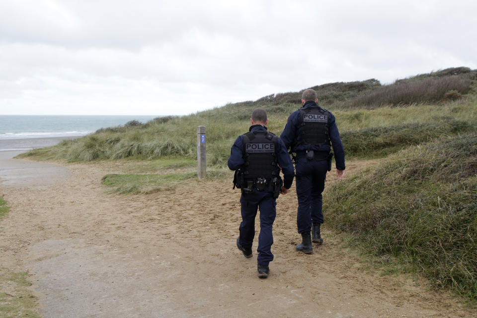 French police officers patrol on the dunes in Wimereux, northern France, Thursday, Nov. 25, 2021 in Calais, northern France. Children and pregnant women were among at least 27 migrants who died when their small boat sank in an attempted crossing of the English Channel, a French government official said Thursday. French Interior Minister Gerald Darmanin also announced the arrest of a fifth suspected smuggler thought to have been involved in what was the deadliest migration tragedy to date on the dangerous sea lane.(AP Photo/Michel Spingler)