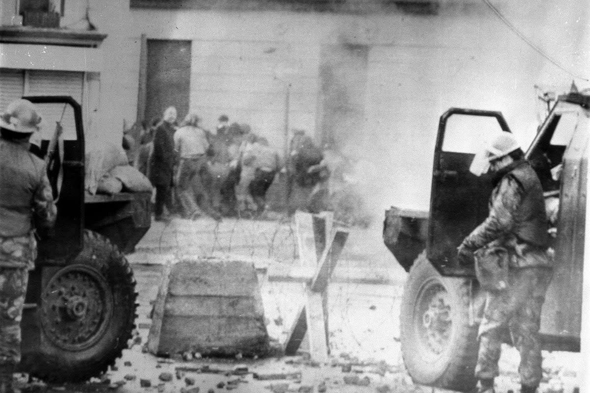 Soldiers take cover behind their sandbagged armoured cars while dispersing rioters with CS gas in Londonderry, where an illegal civil rights march culminated in a clash between troops and demonstrators, which resulted in 13 people being shot dead (PA) (PA Media)