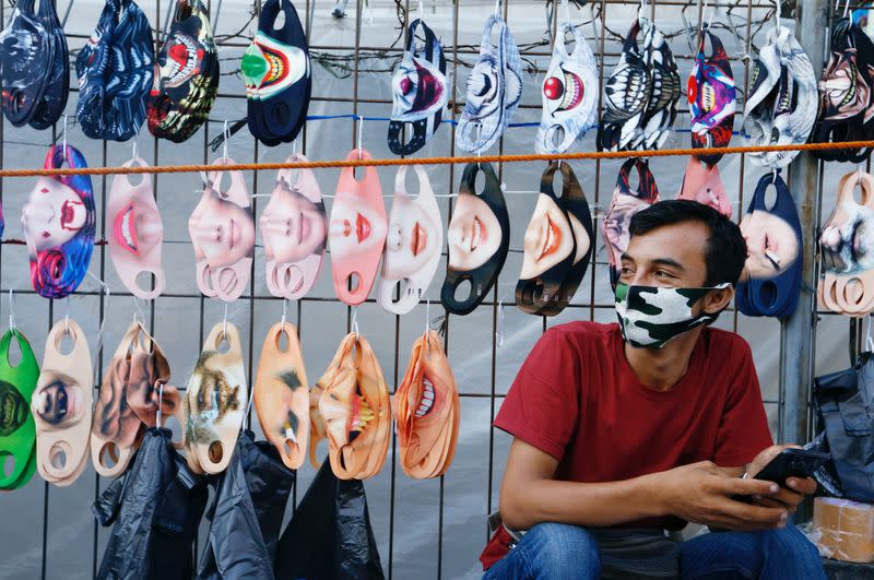 A vendor sits near a face design masks display at a traditional market, amid the coronavirus disease (COVID-19) outbreak, in Jakarta