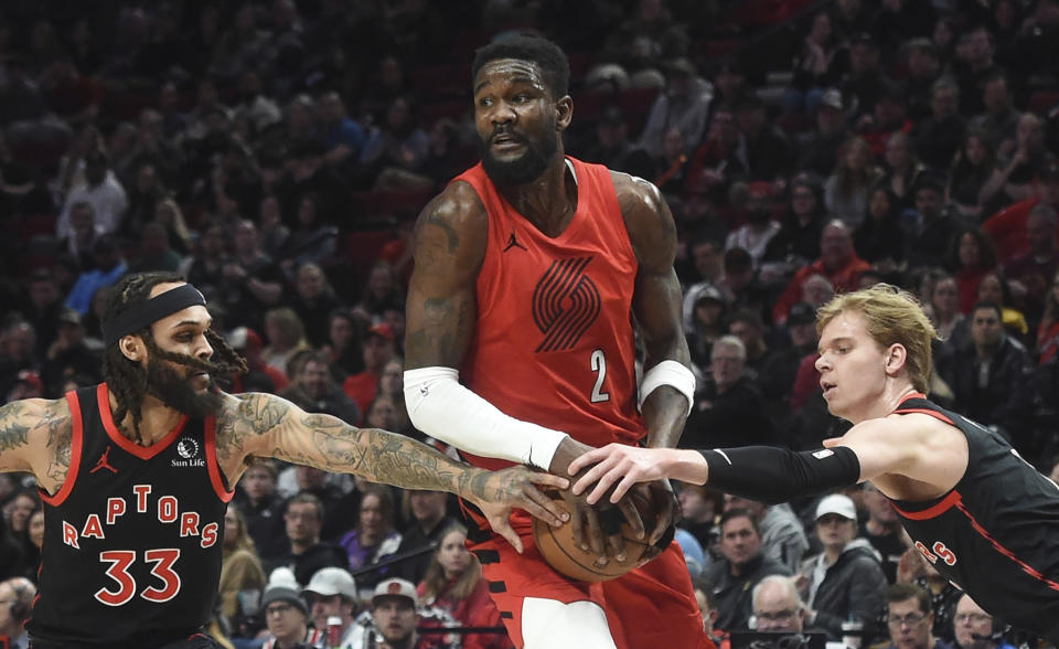 Toronto Raptors guard Gary Trent Jr. (33) and guard Gradey Dick, right, reach in on Portland Trail Blazers center Deandre Ayton (2) during the first half of an NBA basketball game in Portland, Ore., Saturday, March 9, 2024. (AP Photo/Steve Dykes)