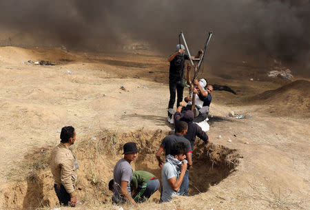 Demonstrators use a large slingshot to hurl stones during clashes with Israeli troops at a protest at the Israel-Gaza border where Palestinians demand the right to return to their homeland, east of Gaza City April 20, 2018. REUTERS/Mohammed Salem