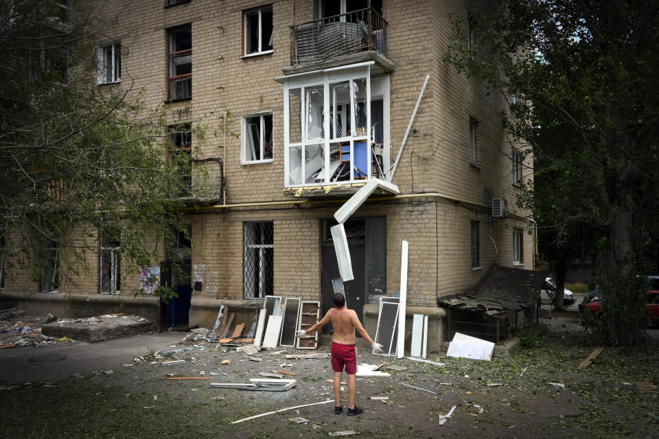 A local resident opens his arms as he looks at his home damaged following Russian night shelling, in Bakhmut, Donetsk region, Ukraine, Monday, June 13, 2022. (AP Photo/Efrem Lukatsky)